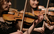 Two women playing violins